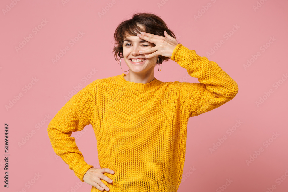 Cheerful young brunette woman girl in yellow sweater posing isolated on pastel pink wall background, studio portrait. People lifestyle concept. Mock up copy space. Showing hello or spok gesture. Cheerful young brunette woman girl in yellow sweater posing isolated on pastel pink wall background, studio portrait. People lifestyle concept. Mock up copy space. Showing hello or spok gesture.