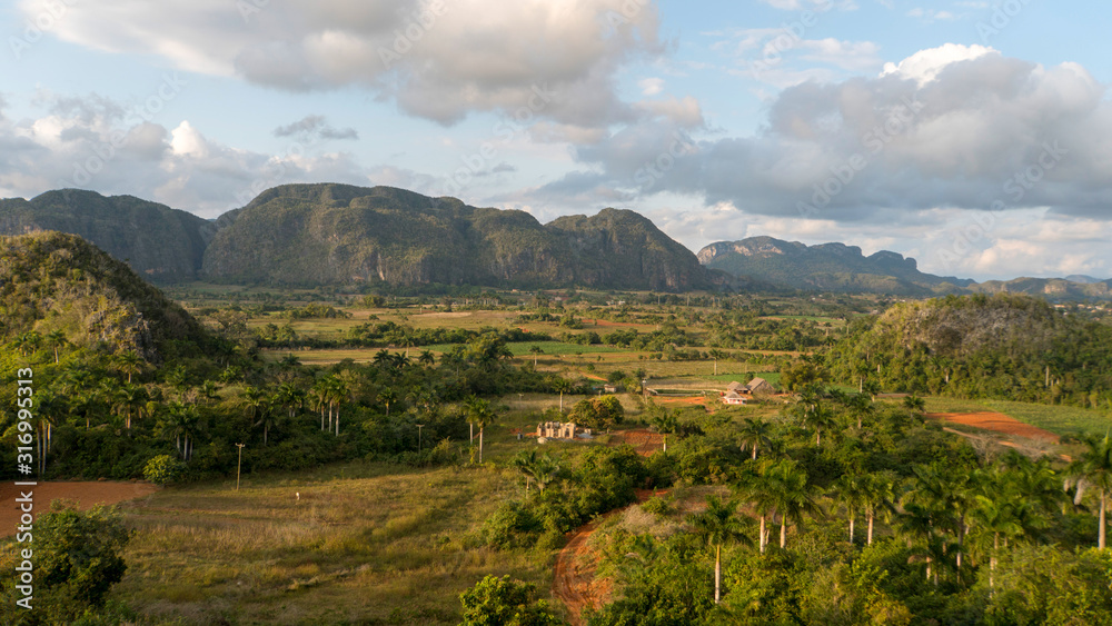 Fototapeta premium vinales valley landscape with moutains, clouds, many trees and farms, cuba