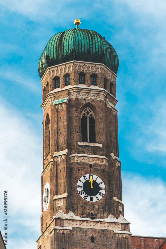 Munich Frauenkirche, Munich cathedral, The Frauenkirche, Cathedral of Our Lady shot from below on sunny day. Close shot of the church tower. Gothic style church, just one tower. Munich Frauenkirche, Munich cathedral, The Frauenkirche, Cathedral of Our Lady shot from below on sunny day. Close shot of the church tower. Gothic style church, just one tower.