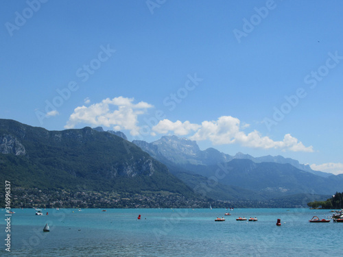 Mountains, blue sky and some white clouds behind Lake Annecy.