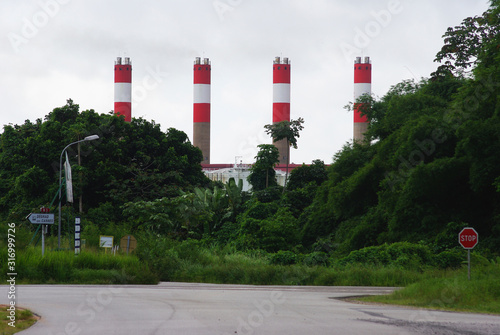 Fotografi Four chimneys of the plant in the jungle of French Guiana.