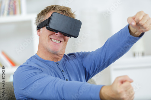 mature man playing driving game wearing virtual reality headset