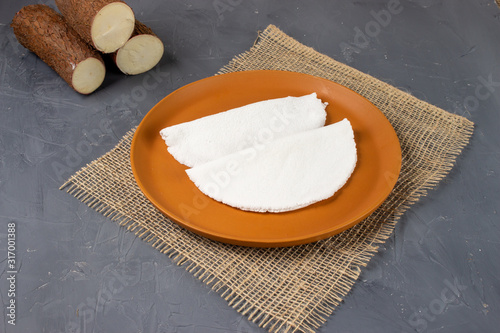 Tapioca, a traditional brazilian snack made from cassava flour. Cassava and dry coconut on the back.  photo