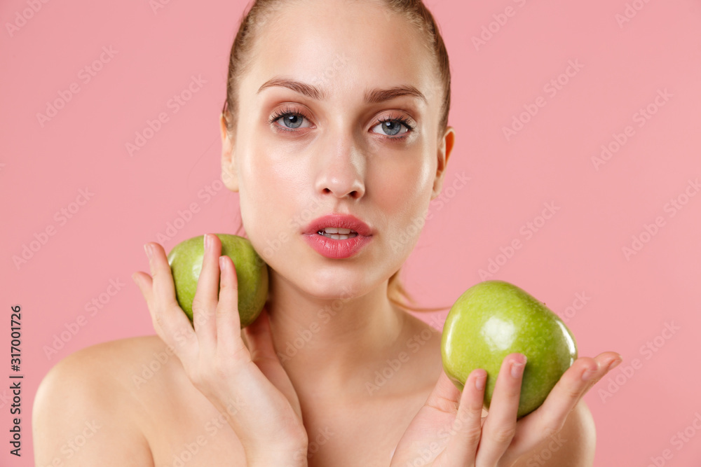 Close up blonde half naked woman 20s perfect skin nude make up hold apple isolated on pastel pink wall background studio portrait. Skin care healthcare cosmetic procedures concept. Mock up copy space. Close up blonde half naked woman 20s perfect skin nude make up hold apple isolated on pastel pink wall background studio portrait. Skin care healthcare cosmetic procedures concept. Mock up copy space.