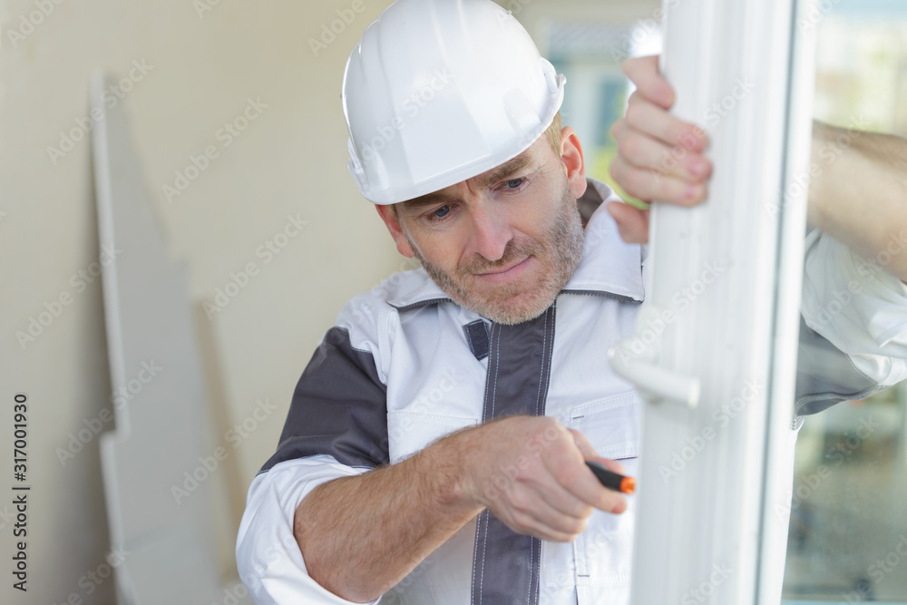 construction worker fixing the window in a new house construction worker fixing the window in a new house