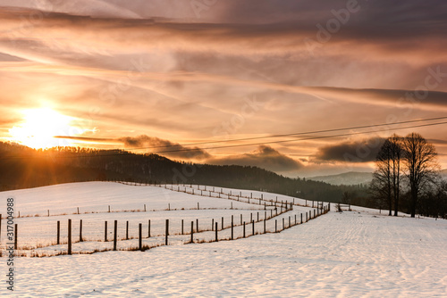 Beautiful Sunset over Snow Covered Farmland and Fields in Bieszczady, Poland