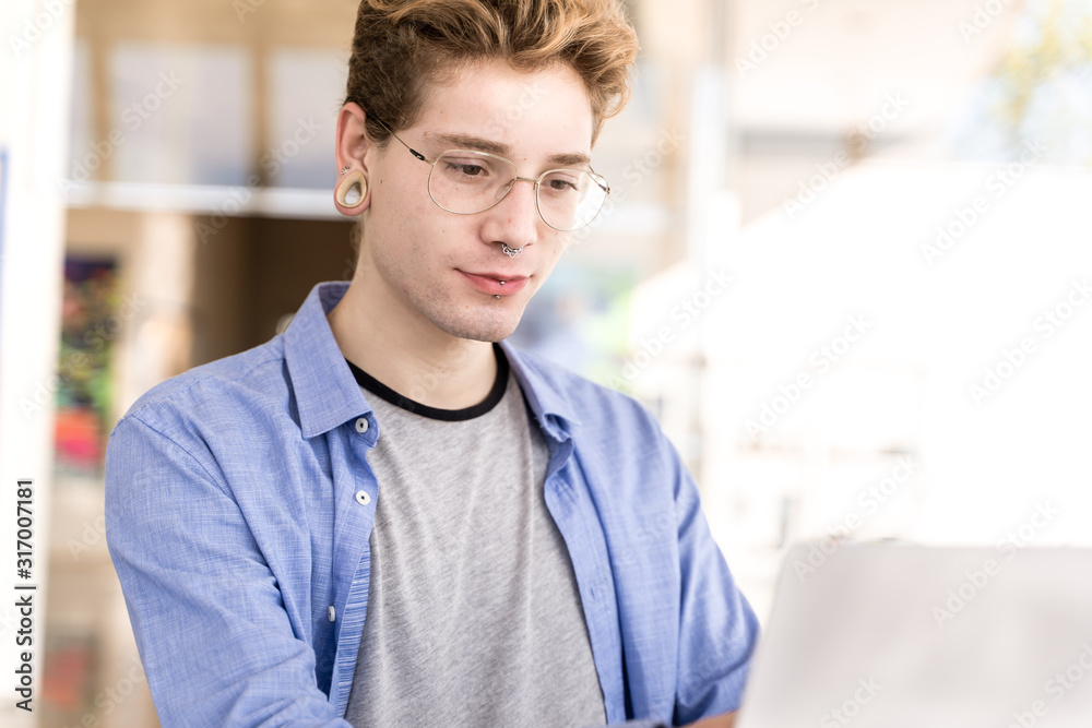 Portrait of a young boy with piercings with concentrated expression Portrait of a young boy with piercings with concentrated expression