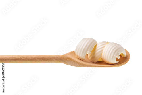 Butter curl on a wooden spoon isolated on white background with clipping path.