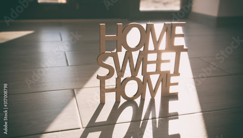 Phrase Home, sweet home made of wood on the background of new house photo