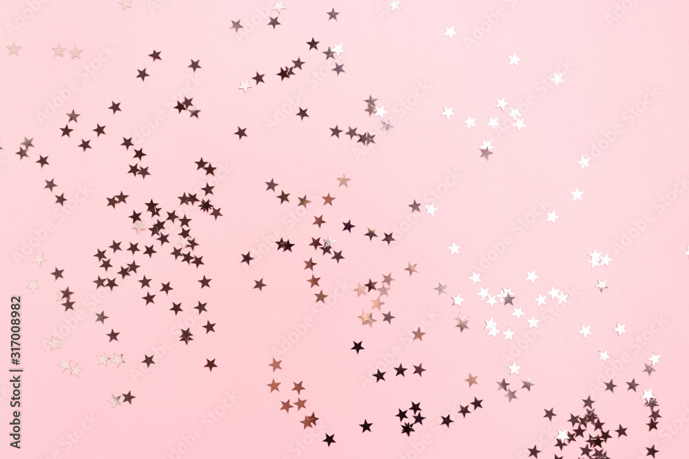 Stars confetti scattered on pink pastel background. Monochromatic concept.