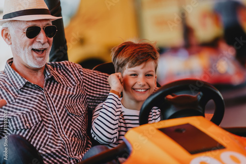 Wallpaper Mural Grandfather and grandson having fun and spending good quality time together in amusement park