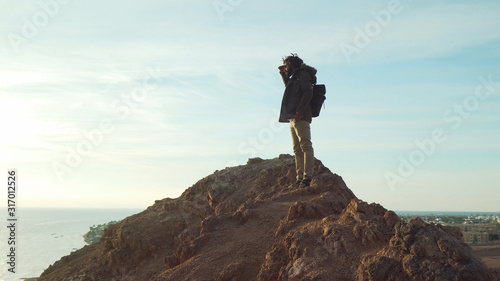 handsome middle eastern male with dreadlocks looking ahead at sunrise