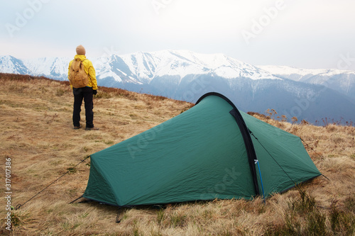 Tourist pitch a tent in spring mountains. Amazing highland. Landscape photography