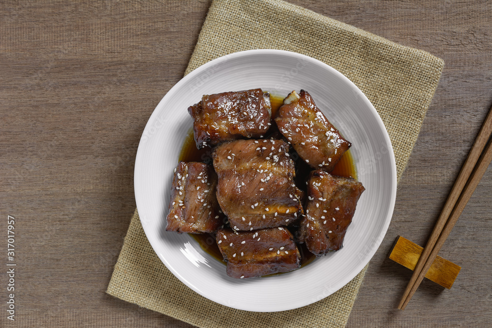 top view of grilled pork rib with teriyaki sauce in a ceramic dish on wooden table. asian homemade style food concept. top view of grilled pork rib with teriyaki sauce in a ceramic dish on wooden table. asian homemade style food concept.