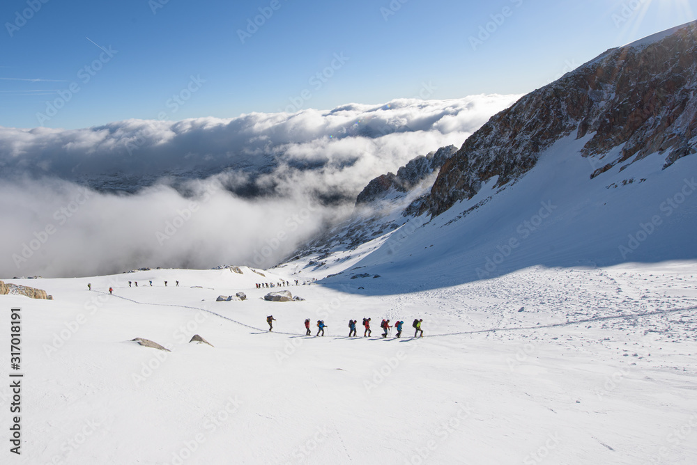Alpinistas subiendo montaña nevada