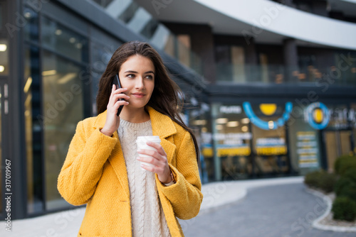 Young woman talking mobile phone and drink coffee