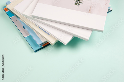 a stack of photo books and magazines lying on a light blue background