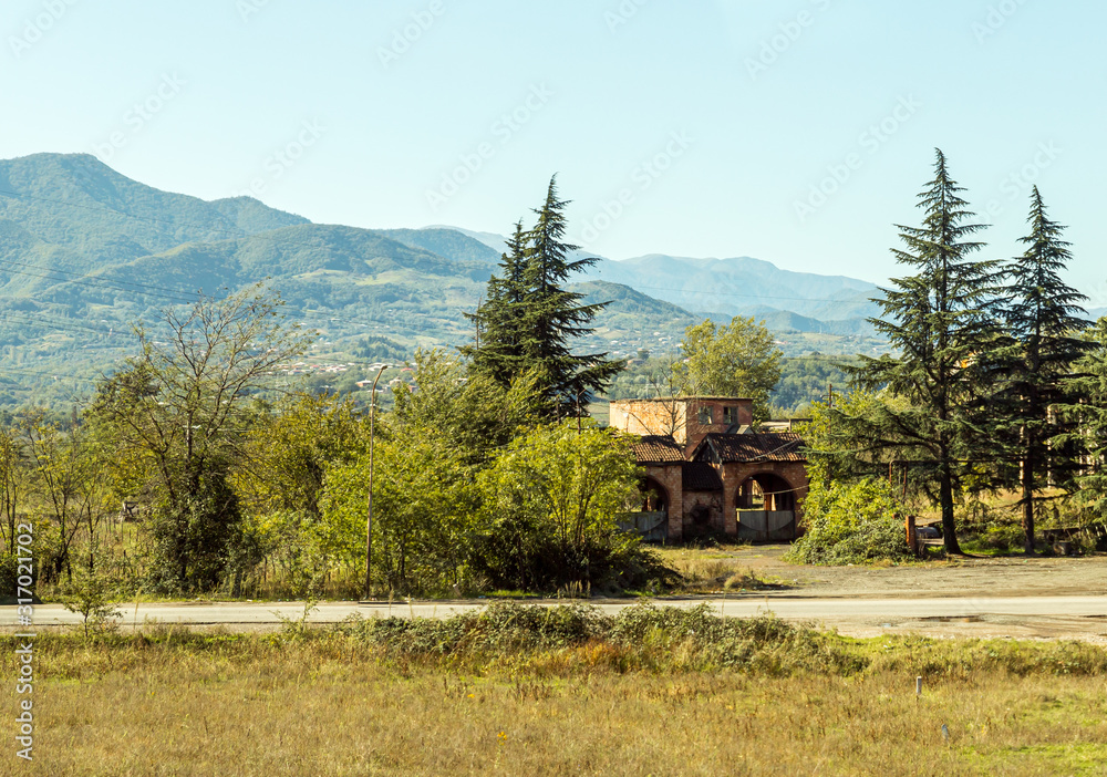 Obraz premium View from the road to the ruined old building in the forest in Imereti in Georgia