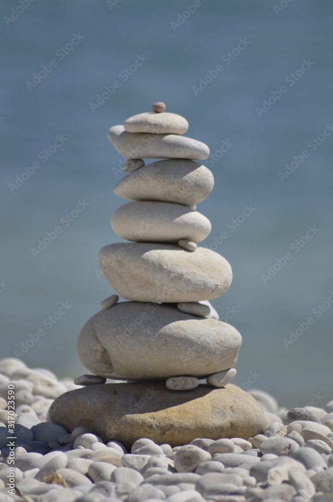 Keep the balance.... a carefully stacked tower of pebbles on a stone beach Keep the balance.... a carefully stacked tower of pebbles on a stone beach