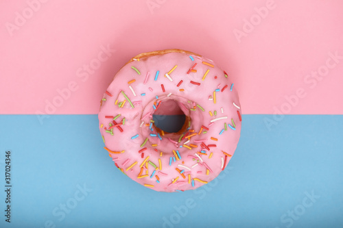 Pink donut on pink-blue background, minimalism concept, color play. Pink t blue background, copy space, shot from above. Different looks of one unit.