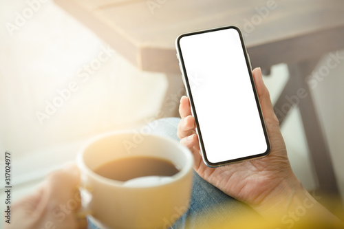 Mockup image blank white screen cell phone.man hand holding texting using mobile on desk at coffee shop.background empty space for advertise text.people contact marketing business,technology 