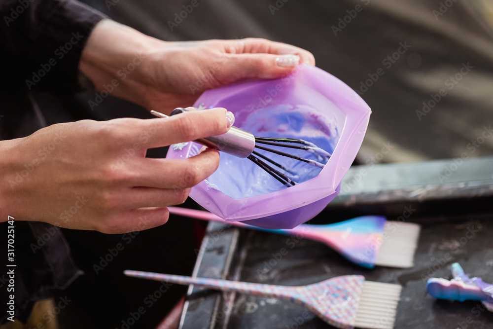 Fototapeta premium Hairdresser colorist kneads paint for hair dyeing.