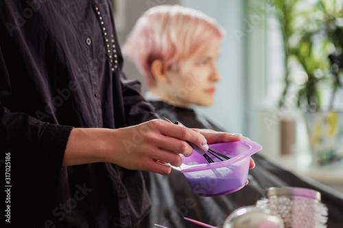 Foto Hairdresser colorist kneads paint for hair dyeing.