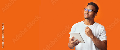 Pensive black guy portrait on orange background photo