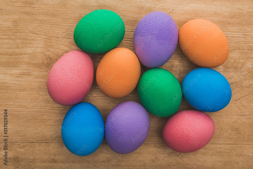 top view of rainbow painted Easter eggs on wooden table