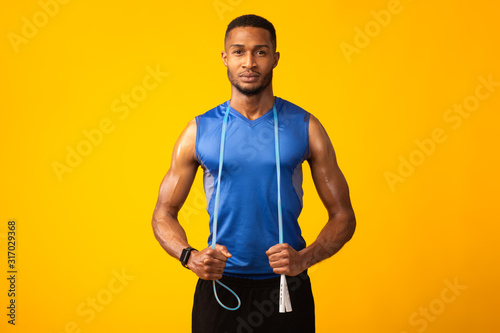 Focused serious afro sportsman with skipping rope
