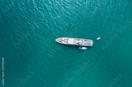 Big luxury yacht anchoring on water, aerial view. Active life style, water transportation and marine sport