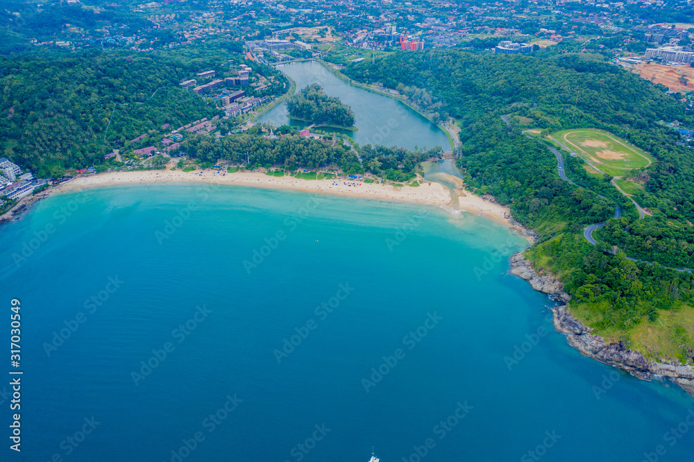 Aerial view of beautiful tropical beach and sea with palm and other tree in Phuket island for travel and vacation. Nai Han Beach