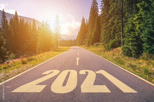 Empty asphalt road and New year 2021 concept. Driving on an empty road in the mountains to upcoming 2021 and leaving behind old 2020. Concept for success and passing time.