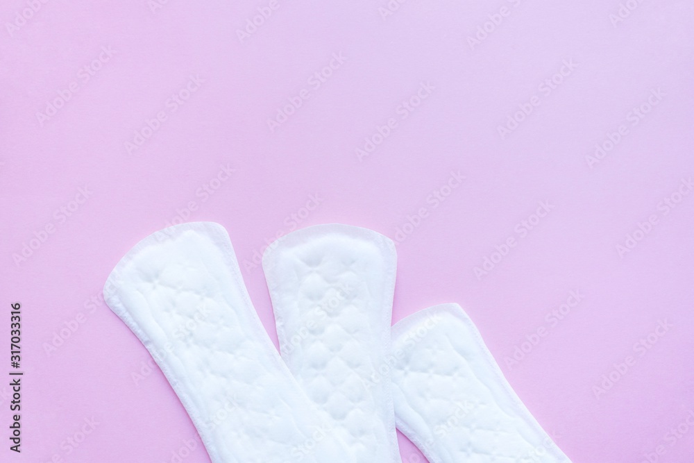 Sanitary pads on a pink background. An alternative choice of feminine hygiene products. Menstrual mothly cycle, means of protection. Top view, flat lay, copy space for text. Sanitary pads on a pink background. An alternative choice of feminine hygiene products. Menstrual mothly cycle, means of protection. Top view, flat lay, copy space for text.