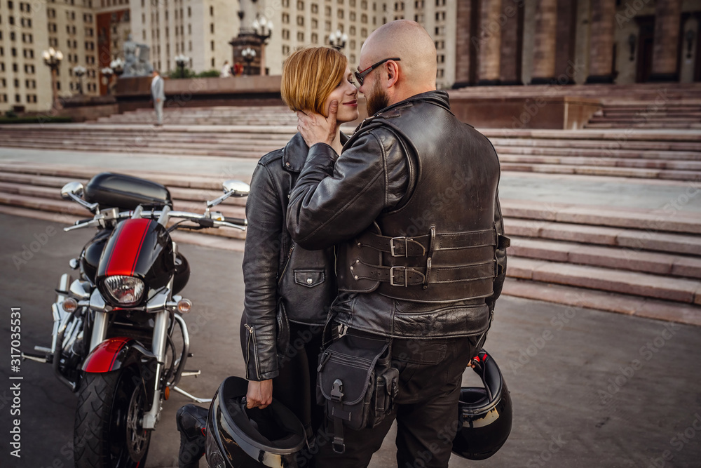 Beautiful couple on a cool motorcycle against Moscow