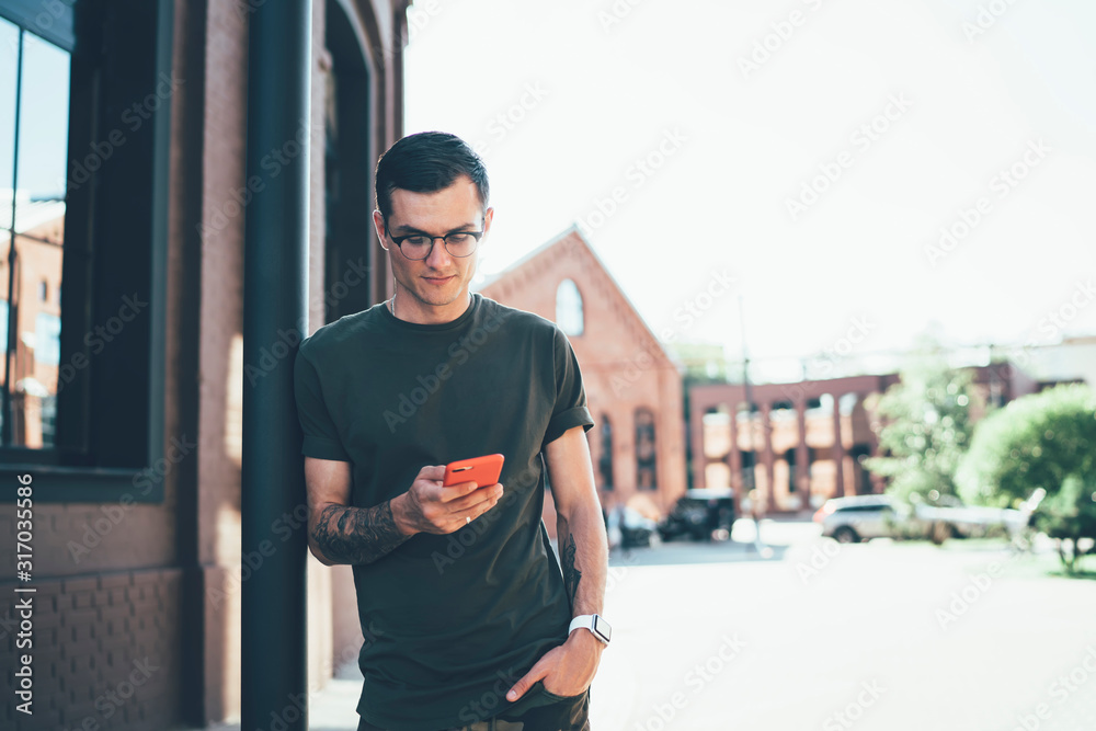 Young man in casual wear using smartphone at city street Young man in casual wear using smartphone at city street