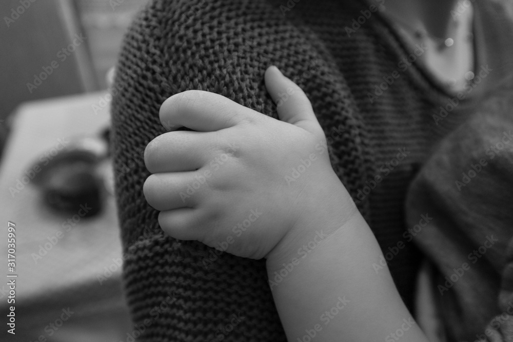 Children's hands. The child holds his mom. Children's fist. Black and white photo.