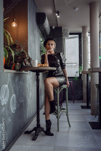 Young elegant woman drinking coffee in traditional cafe in Paris, France