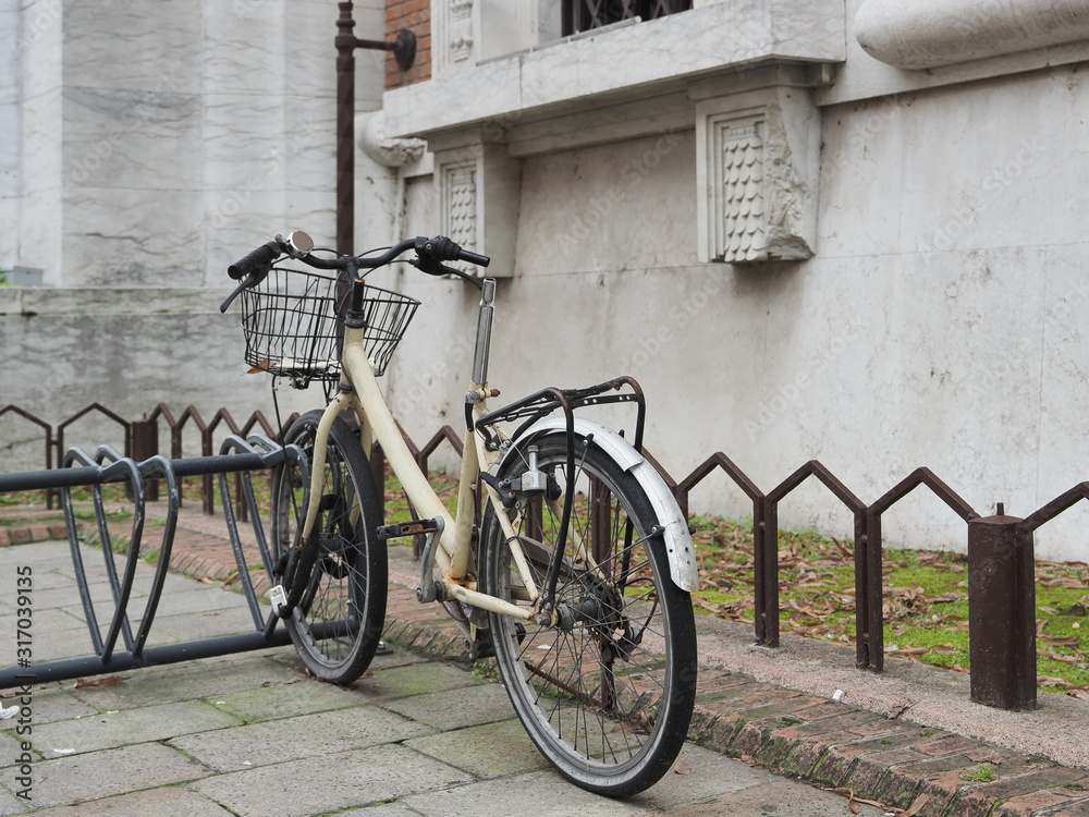 Bicycle vandalized next to an old building.