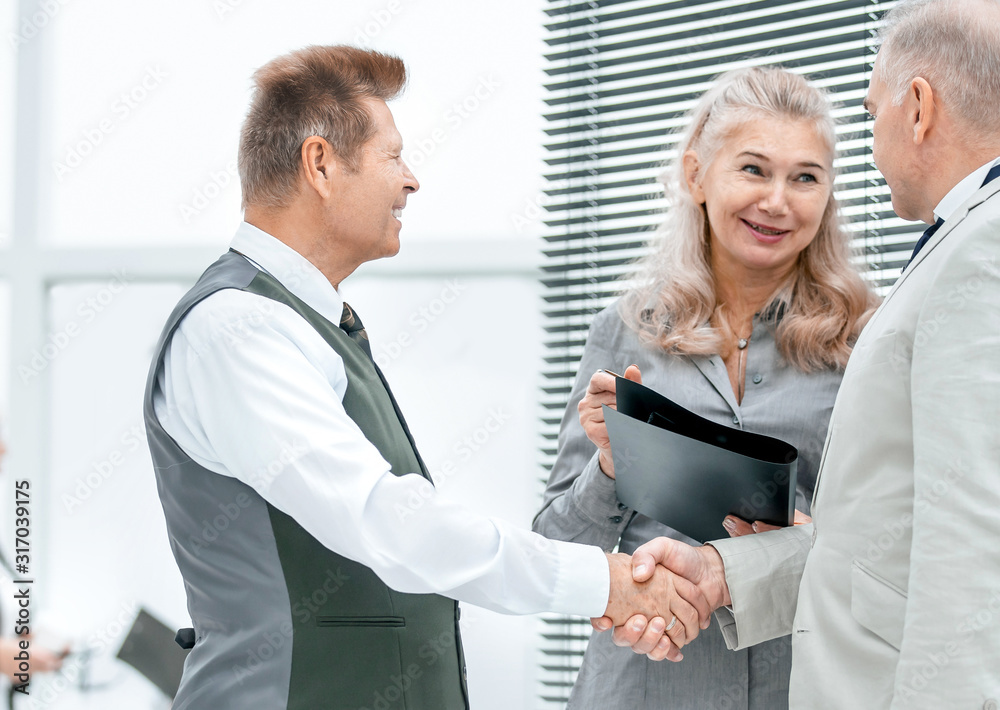 close up. Manager and customer shaking hands close up. Manager and customer shaking hands
