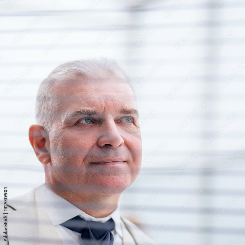 close up. pensive businessman looking through window blinds close up. pensive businessman looking through window blinds