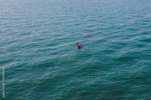 aerial of a person on small boat alone on ocean -