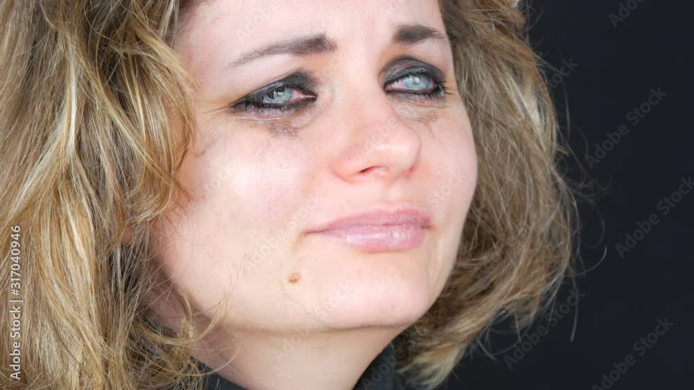 Depressive sad tearful girl with smeared makeup and lipstick on her face crying with real tears Depressive sad tearful girl with smeared makeup and lipstick on her face crying with real tears