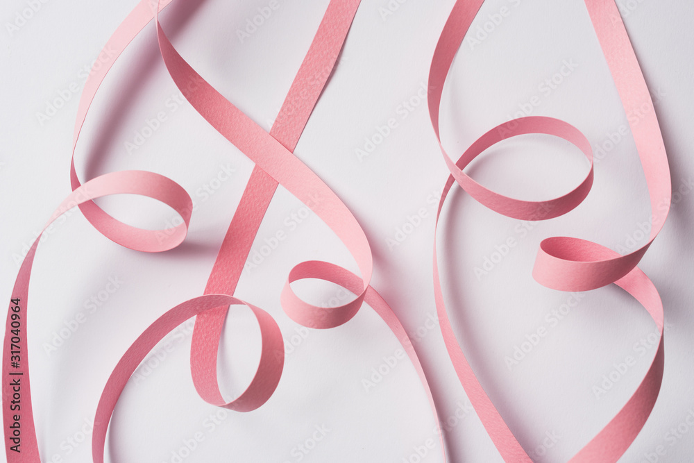 top view of pink paper swirl on white background