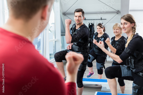 Group of people having ems training in the electro gym photo