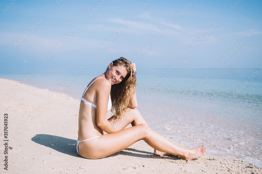 Slim female resting on beach near clean sea Slim female resting on beach near clean sea