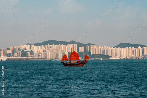 Traditional, old sailing boat on Victoria Harbour with skyline of Hong Kong Island