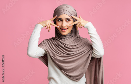 Mysterious muslim girl in hijab framing her eyes with fingers © Prostock-studio