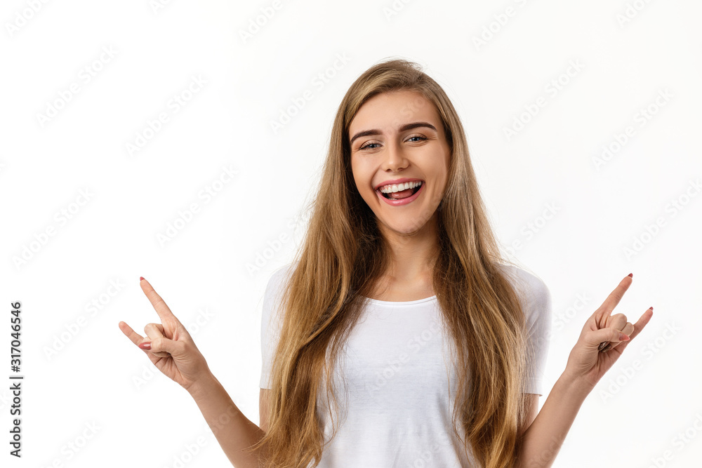 smiling young woman showing rock and roll hand and looking at camera on white background. smiling young woman showing rock and roll hand and looking at camera on white background.