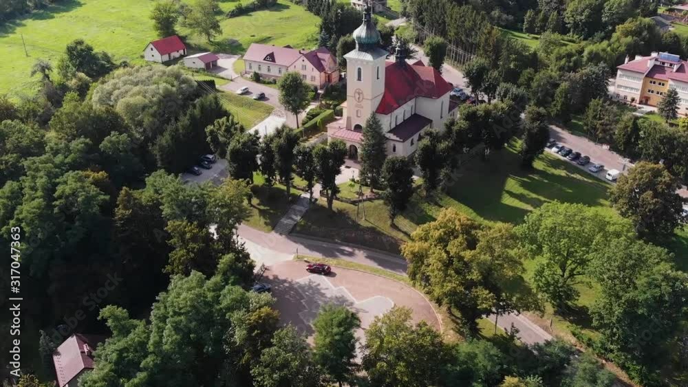 Zabytkowy kościół wśród drzew na polskiej wsi z lotu ptaka Zabytkowy kościół wśród drzew na polskiej wsi z lotu ptaka